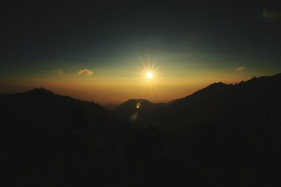 Scenic view of silhouette mountains against sky during sunset