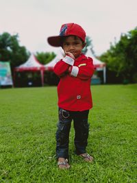 Full length of boy standing on grassy field