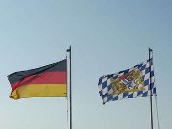 Low angle view of flags against clear sky