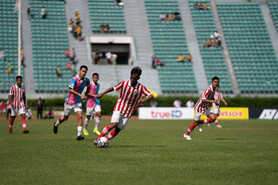 Group of people playing soccer on field