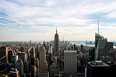 Modern buildings in city against cloudy sky