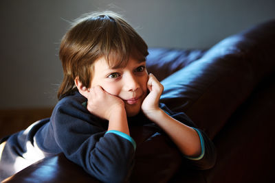 Side view of young woman sitting on sofa at home