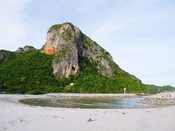 Scenic view of rocks by sea against sky