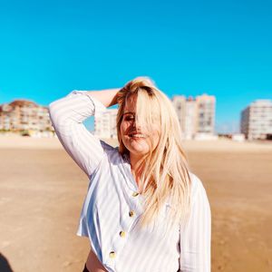 Portrait of a smiling young woman against blue sky