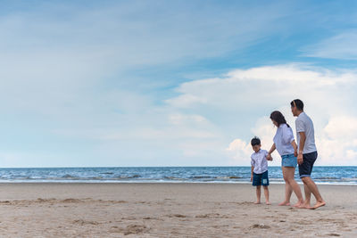 Full length of family walking at beach