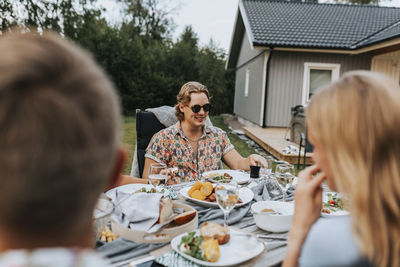 Rear view of man and woman sitting on table