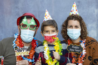 Portrait of family wearing mask standing against wall