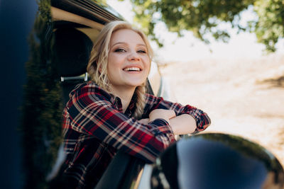 Portrait of smiling young woman sitting outdoors