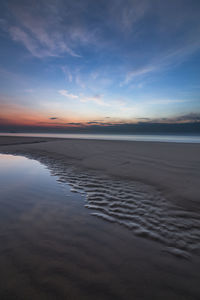 Scenic view of beach against sky during sunset