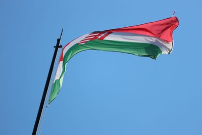 Low angle view of flag against blue sky