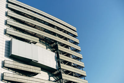 Low angle view of modern building against clear blue sky