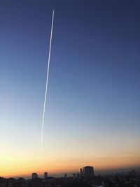 Scenic view of vapor trails in sky during sunset