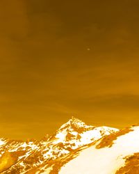 Scenic view of snowcapped mountains against sky during sunset