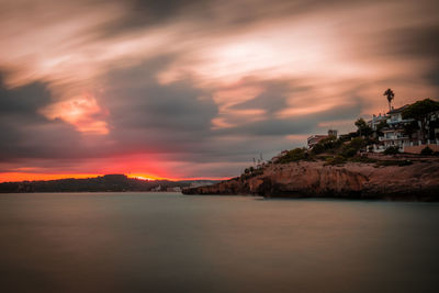 Scenic view of sea against dramatic sky during sunset