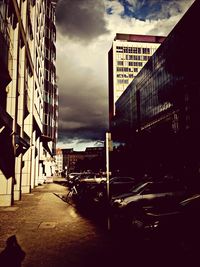 Buildings in city against cloudy sky