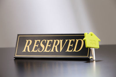 Close-up of reserved sign and key on table