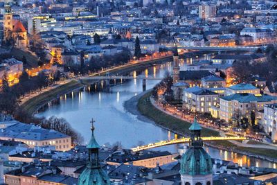 High angle view of illuminated buildings and bridge at dusk