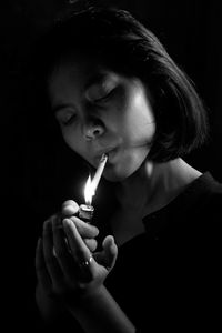 Close-up of woman lighting cigarette using lighter