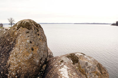 Scenic view of rocks on beach against clear sky