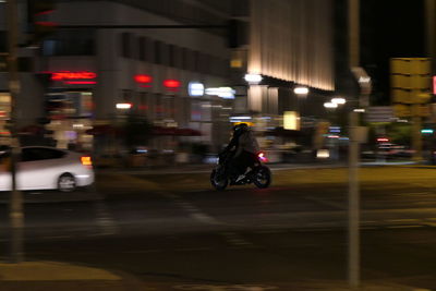 Man riding motorcycle on street at night