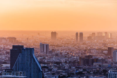 High angle view of buildings in city at sunset