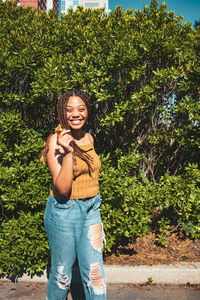 Portrait of smiling girl standing against trees