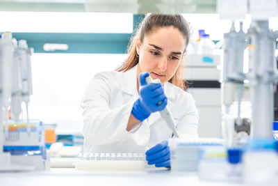 Young businesswoman drinking in laboratory