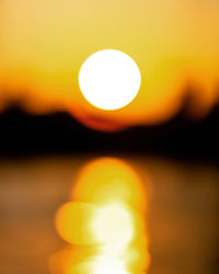 Defocused image of sun against sky during sunset