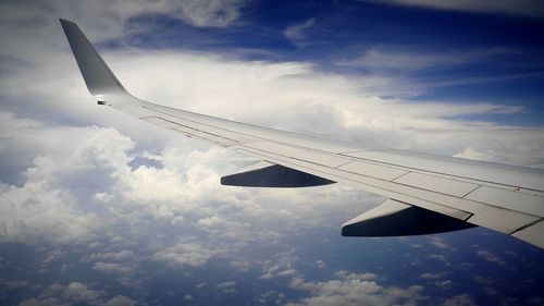 Cropped image of airplane flying over clouds