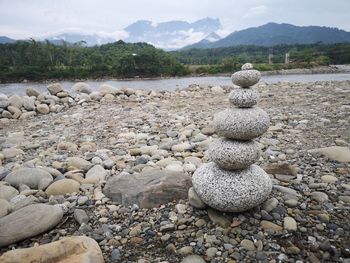 Stack of stones on shore against sky