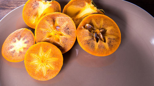 Persimmon on a plate on a wooden table,copy space