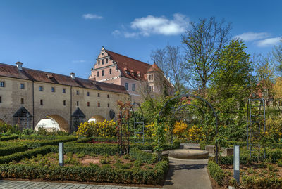 Plants by old building against sky