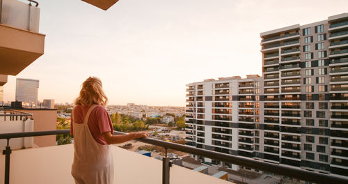 Side view of woman with dog against building