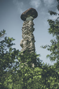 Low angle view of old statue against sky