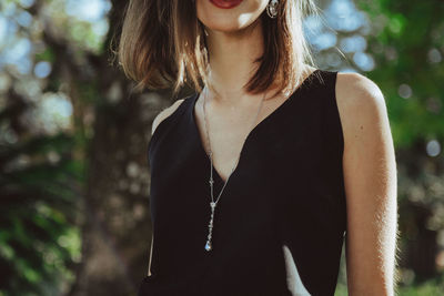 Low section of woman standing against tree