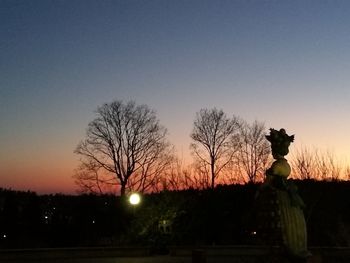 Silhouette of bare tree against clear sky at sunset
