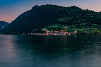 Scenic view of sea by mountains against sky
