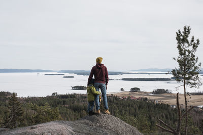 Father and son standing on top of a hill together enjoying the view