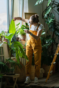 Woman standing by potted plants