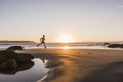 France, crozon peninsula, jogger on the beach at sunset