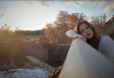 Portrait of young woman against sky