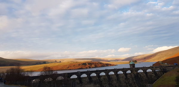 Bridge over mountain against sky