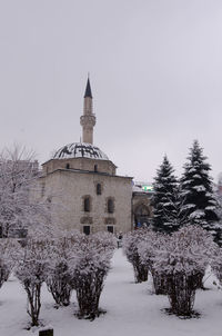 Building on snow covered field against sky