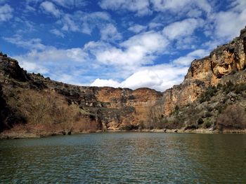 Scenic view of river against cloudy sky