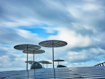 Low angle view of telephone on roof against sky