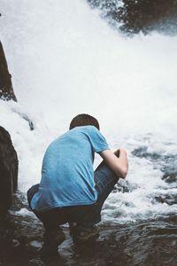 Rear view of man looking at a waterfall