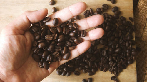 Cropped image of hand holding coffee beans