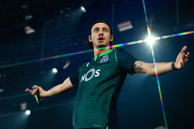 Low angle view of young man standing in illuminated room