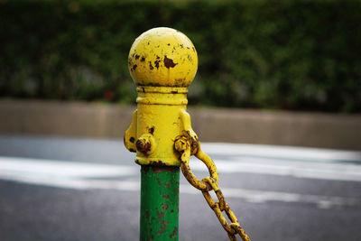 Close-up of old bollard on street