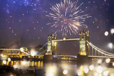 Firework display over illuminated city at night